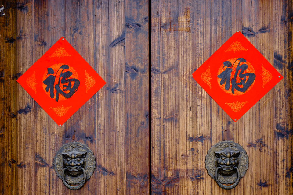 The Handwriting Chinese blessing &quot;Fu&quot; on the wooden door with traditional chinese bronze handle during the Chinese New Year