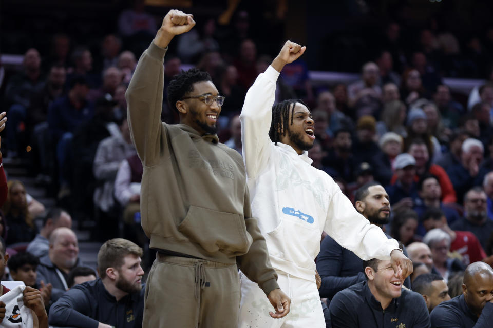 Injured Cleveland Cavaliers guards Donovan Mitchell, left, and Darius Garland cheer from the bench during the first half of an NBA basketball game against the Detroit Pistons, Wednesday, Feb. 8, 2023, in Cleveland. (AP Photo/Ron Schwane)