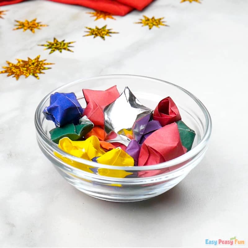 Glass bowl full of mini origami stars in various colors