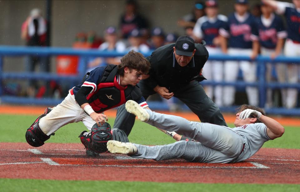 Ketchem catcher Connor Lynch attempts a tag on Arlington baserunner Brandan Bisceglia (27)  during their 5-3 win over Arlington in the Class AA baseball championship game at Purchase College in Purchase, on Saturday, May 28, 2022.