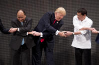 <p>U.S. President Donald Trump, center, reacts as he does the “ASEAN-way handshake” with Vietnamese Prime Minister Nguyen Xuan Phuc, left, and Philippine President Rodrigo Duterte on stage during the opening ceremony at the ASEAN Summit at the Cultural Center of the Philippines, Nov. 13, 2017, in Manila, Philippines. Trump initially did the handshake incorrectly. Trump is on a five-country trip through Asia traveling to Japan, South Korea, China, Vietnam and the Philippines. (Photo: Andrew Harnik/AP) </p>