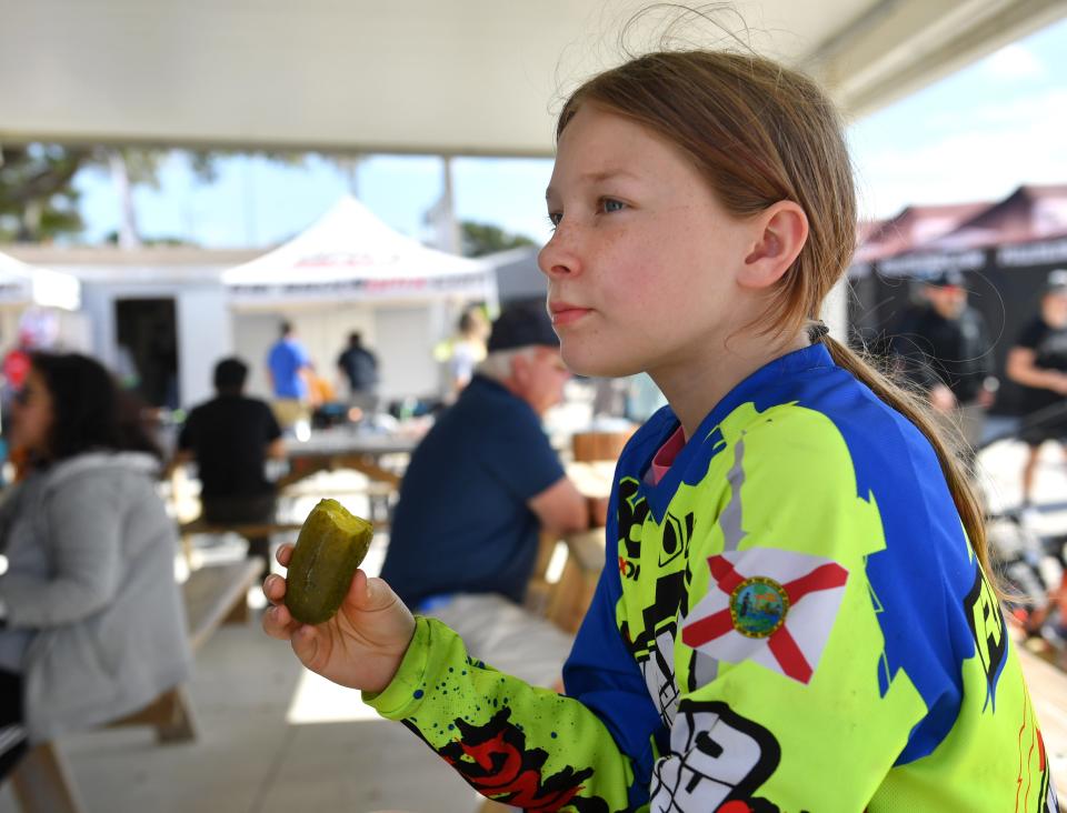 Willow Stewart, 11, from Orlando, munches on a dill pickle after her morning practice session.