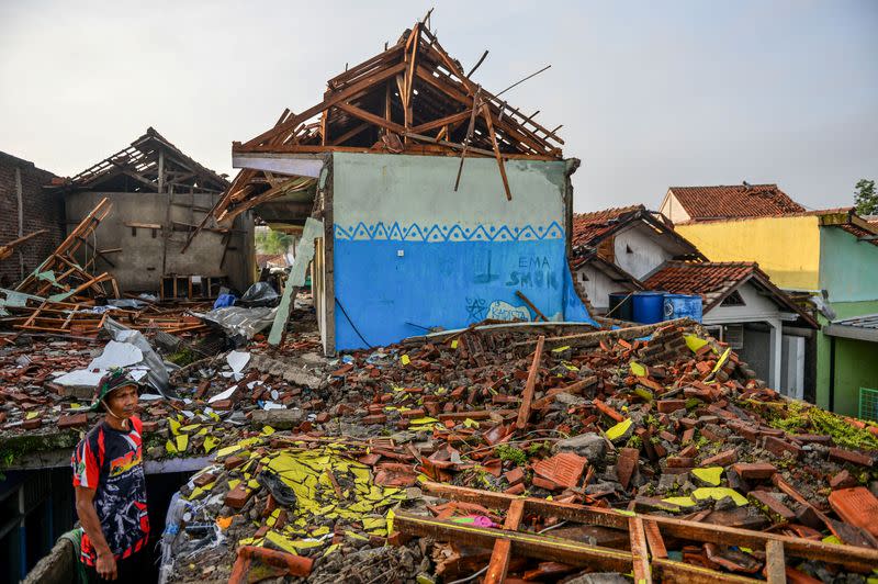 A man stands near damaged houses following a tornado at Sukadana village in Sumedang