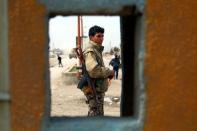 A member of the US-backed Syrian Democratic Forces stands in the town of Al-Karamah, near the Islamic State (IS) group bastion of Raqa on March 26, 2017