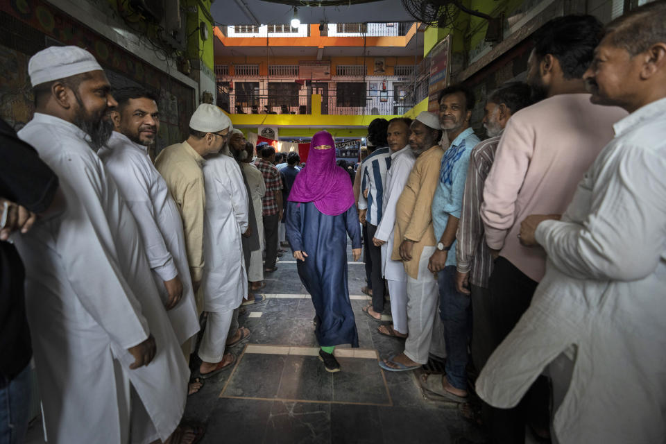 A voter leaves after casting her vote as others queue up to cast their vote in the sixth round of polling in India's national election in New Delhi, India, Saturday, May 25, 2024. (AP Photo/Altaf Qadri)