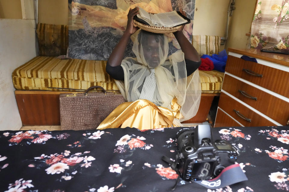 Zimbabwean artist Nothando Chiwanga works on her latest piece, covering her face with a transparent white veil while taking self portraits with a camera, in Harare, Friday, March 24, 2023. Chiwanga is one of 21 female artists whose works have been on show at the southern African country's national gallery since International Women's Day on March 8. The exhibition is titled "We Should All Be Human" and is a homage to women's ambitions and their victories, art curator Fadzai Muchemwa said. (AP Photo/Tsvangirayi Mukwazhi)