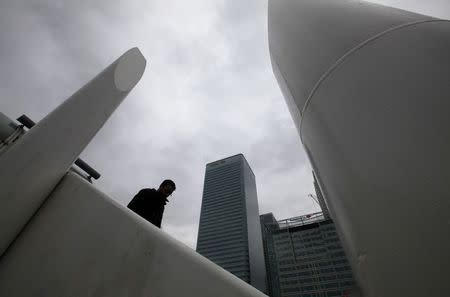 A man stands near the Canary Wharf business district, in east London February 28, 2011. REUTERS/Andrew Winning