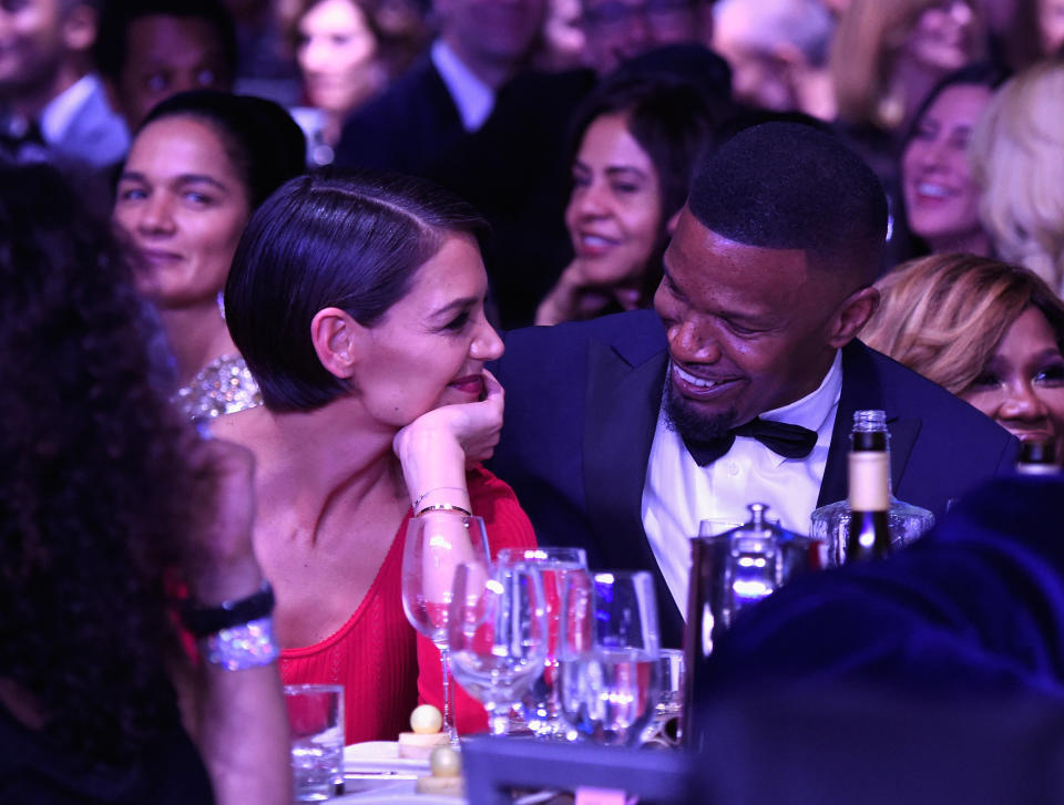 Katie Holmes and Jamie Foxx smile at each other at a pre-Grammy Awards event on Saturday night. (Photo: Kevin Mazur via Getty Images)