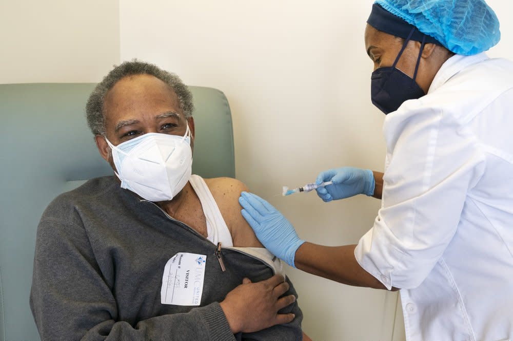 In this Wednesday, Feb. 10, 2021, photo the Rev. James Coleman, 70, is vaccinated for COVID-19 by nurse practitioner Ifreke Udodong at United Medical Center in southeast Washington. (AP Photo/Jacquelyn Martin)