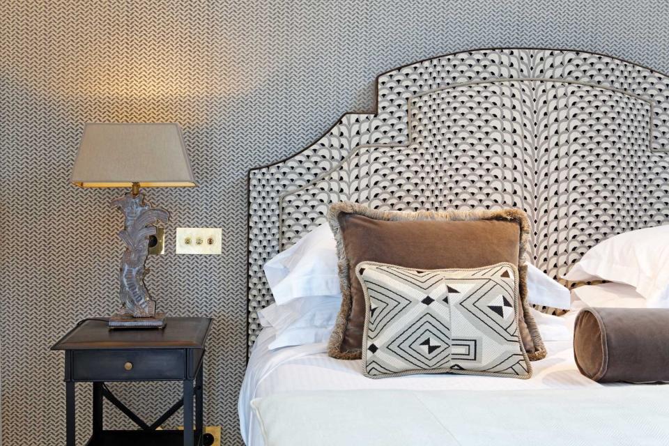 Detail of bed and bedside table of the Relais Christine Hotel in Paris