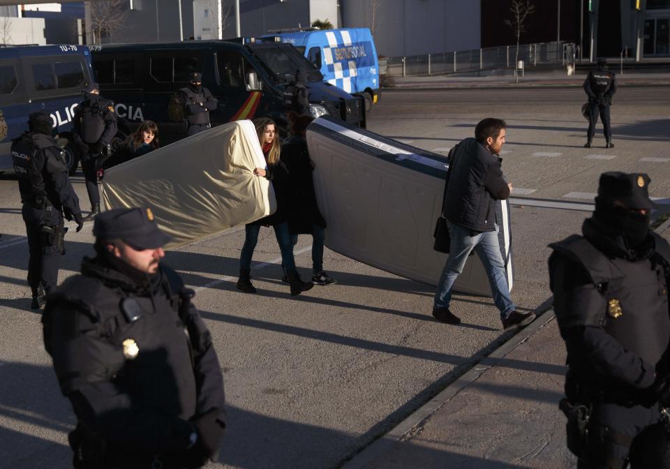 Anti-eviction activists carry mattresses after a family was evicted from their apartment in Madrid