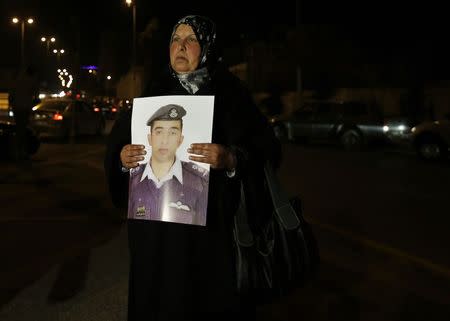 Mother of Islamic State captive Jordanian pilot Muath al-Kasaesbeh holds his picture as she takes part in a demonstration demanding that the Jordanian government negotiate with Islamic state and for the release of her son, in front of the prime minister's building in Amman, January 27, 2015. REUTERS/Muhammad Hamed