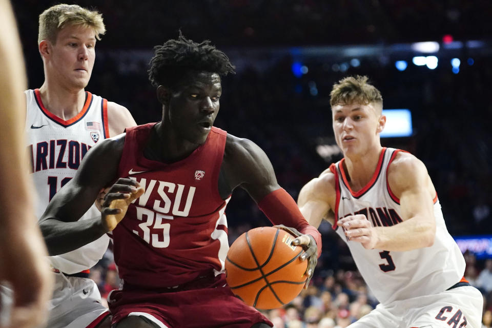 Washington State's Mouhamed Gueye (35) looks to get out of a double-team by Arizona's Azuolas Tubelis, left, and Pelle Larsson, right, during the first half of an NCAA college basketball game, Saturday, Jan. 7, 2023, in Tucson, Ariz. (AP Photo/Darryl Webb)