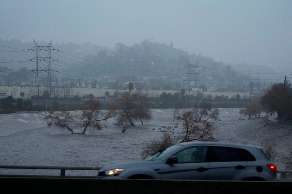 PHOTO: Motorists cross a bridge over the Los Angeles River, carrying stormwater downstream in Los Angeles, Feb. 4, 2024. The second of back-to-back atmospheric rivers is drenching Northern California. (Damian Dovarganes/AP)