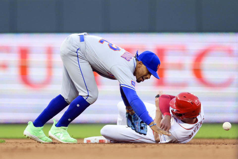 New York Mets' Francisco Lindor, left, reacts as he attempts to field the ball as Cincinnati Reds' Wil Myers reaches second base during the fifth inning of a baseball game in Cincinnati, Tuesday, May 9, 2023. (AP Photo/Aaron Doster)