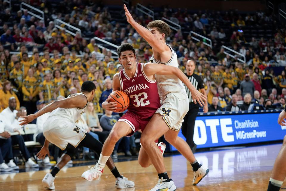 Indiana guard Trey Galloway (32) drives on Michigan forward Will Tschetter (42) in the first half of a basketball game in Ann Arbor, Michigan on Dec. 5, 2023.