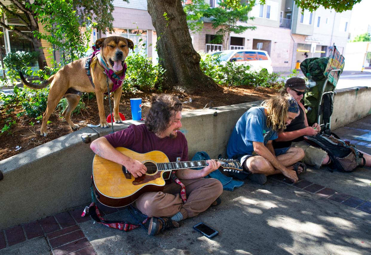 Jonah Ryan, left, who lives on the street with his dog, Jesse, joins Roach (middle) and others in downtown Eugene in August 2022. Mayors from around Oregon have created a statewide plan and submitted it to the state with a request for funding and assistance.