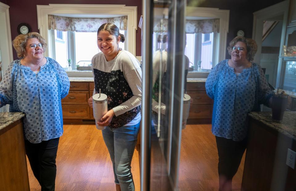 Janet Sanford, left, is reflected in her refrigerator as she and her daughter Audrey Sanford, 21, share a laugh in Janet's Albion home on Monday, April 15, 2024.