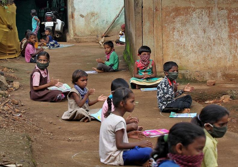 印度疫情時期的上課狀況，雖然地上畫有社交距離，但很多孩子依然沒有口罩。News18