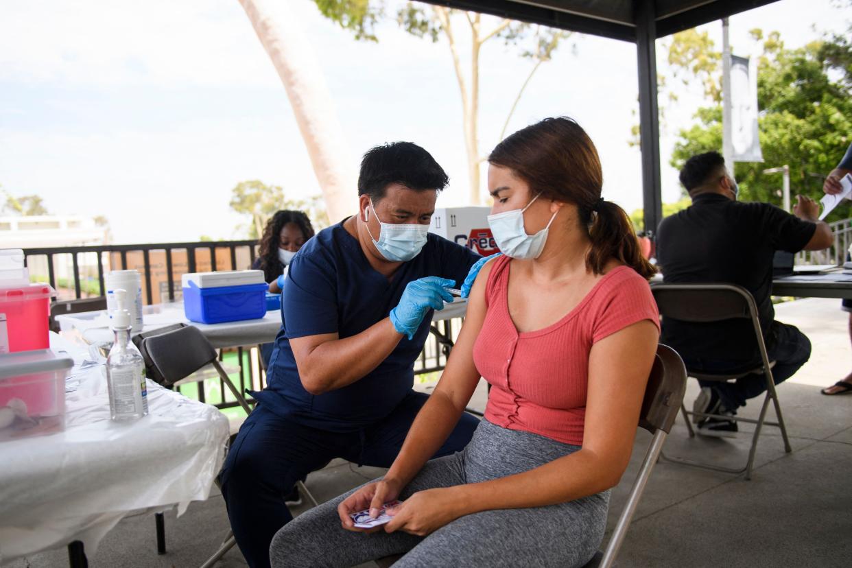 A CSULB student receives a first dose of the Pfizer COVID-19 vaccine at mobile vaccination clinic at the California State University Long Beach (CSULB) campus on Aug. 11, 2021, in Long Beach, Calif. Students, staff, and faculty at the California State University (CSU) and University of California (UC) system schools will be required to be fully vaccinated in order to attend in-person classes. All teachers in California will have to be vaccinated against COVID-19 or submit to weekly virus tests, the state's governor announced June 11, as authorities grapple with exploding infection rates.