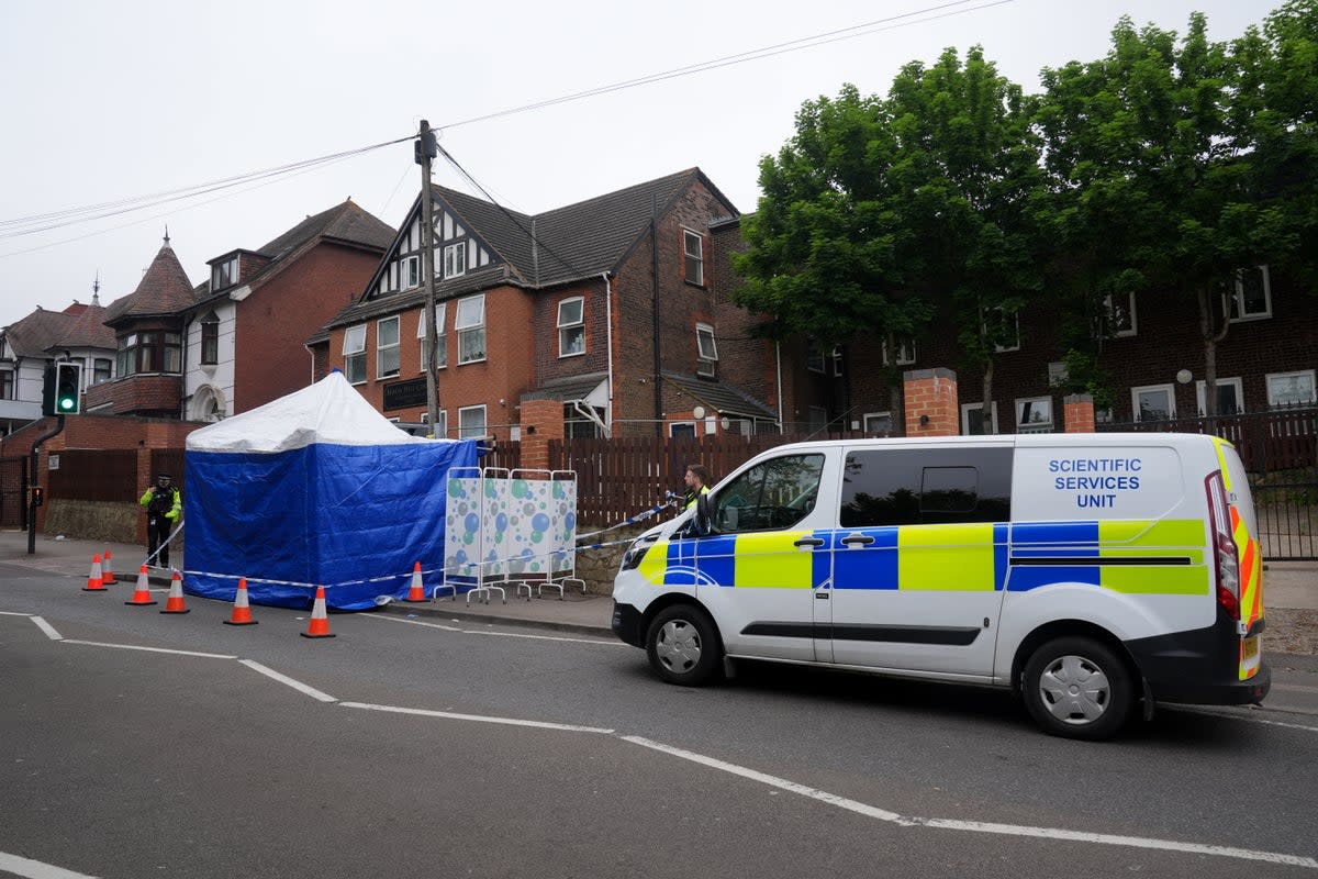 Police at the scene of the stabbing in Dunstable Road  (Lucy North/PA Wire)