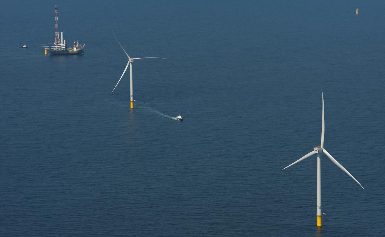 The Danish ship Sea Installer, at the top of photo, carries components for a wind turbine on Monday at the Vineyard Wind 1 offshore wind farm site 12 miles south of Martha's Vineyard. The vessel sits beside a monopile foundation ready for installation of another turbine.