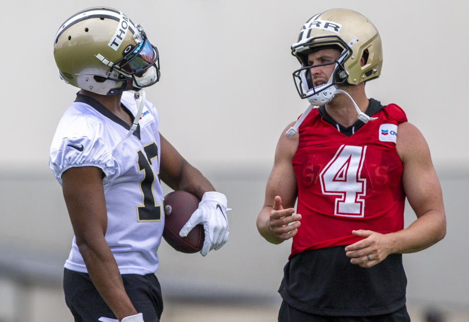 New Orleans Saints wide receiver Michael Thomas (13) talks with quarterback Derek Carr (4) during NFL football practice in Metairie, La., Tuesday, June 6, 2023. (Catie Shea/The Times-Picayune/The New Orleans Advocate via AP)