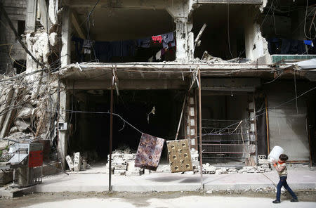 A boy is seen in the besieged town of Douma, Eastern Ghouta, in Damascus, Syria March 8, 2018. REUTERS/Bassam Khabieh