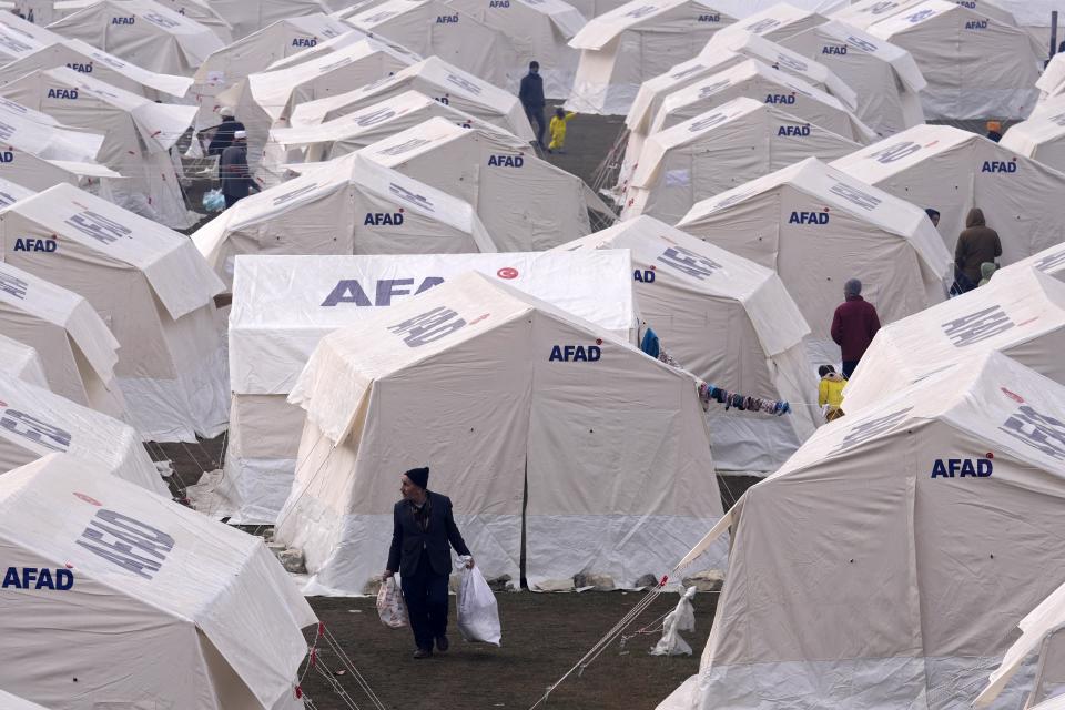 People with their belongings arrive at the tents, in Kharamanmaras, southeastern Turkey, Friday, Feb 10, 2023. Rescuers pulled several people alive from the shattered remnants of buildings on Friday, some who survived more than 100 hours trapped under crushed concrete in the bitter cold after a catastrophic earthquake slammed Turkey and Syria. (AP Photo/Kamran Jebreili)