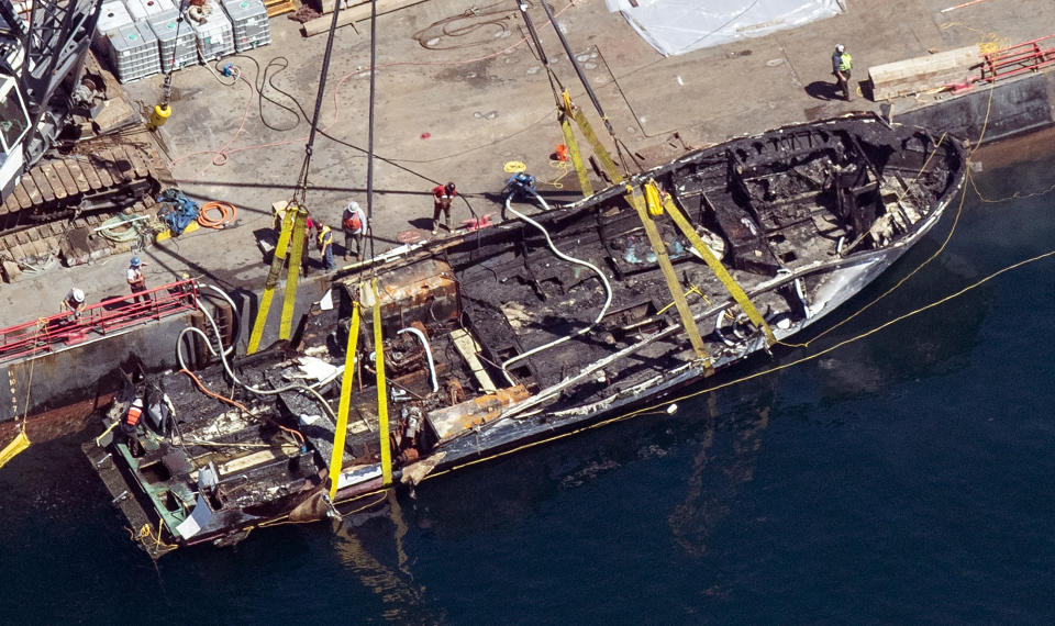 FILE - In this Sept. 12, 2019, file photo, the burned hull of the dive boat Conception is brought to the surface by a salvage team in the Santa Barbara Channel off Santa Cruz Island in Southern California. Coroner's reports for the 34 victims who died in the massive scuba boat fire off the Southern California coast last year show the divers died of carbon monoxide poisoning before they were burned, authorities said Thursday, May 21, 2020. (Brian van der Brug/Los Angeles Times via AP, File)