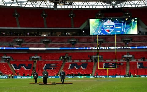 Wembley Stadium ground staff start to get the pitch ready for the premier league game - Credit: Reuters