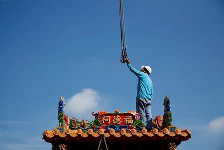 An employee moves a ready-made Chinese traditional temple during delivery in Taichung, Taiwan July 6, 2016. REUTERS/Tyrone Siu