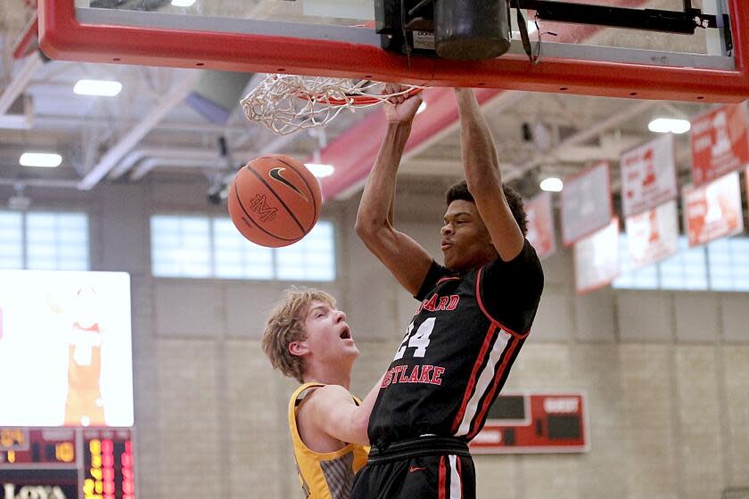 Harvard-Westlake's Isaiah Carroll dunks over Foothill's Danny Kennard in the Wolverines' 74-54 win. Steve Galluzzo / For The Times