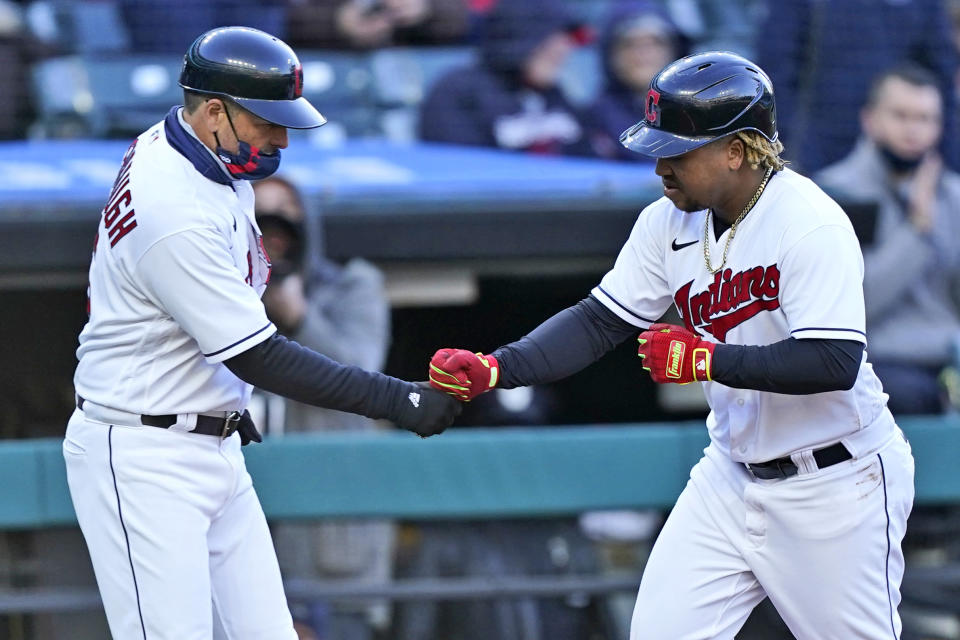 Cleveland Indians third base coach Mike Sarbaugh congratulates Jose Ramirez after Ramirez hit a solo home run in the fourth inning of a baseball game against the Chicago Cubs, Tuesday, May 11, 2021, in Cleveland. Cleveland won 3-2. (AP Photo/Tony Dejak)