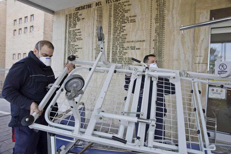 Personnel carry new beds inside the hospital of Codogno, near Lodi in Northern Italy, Friday, Feb. 21,2020. Health officials reported the country's first cases of contagion of COVID-19 in people who had not been in China. The hospital in Codogno is one of the hospitals - along with specialized Sacco Hospital in Milan - which is hosting the infected persons and the people that were in contact with them and are being isolated. (AP Photo/Luca Bruno)