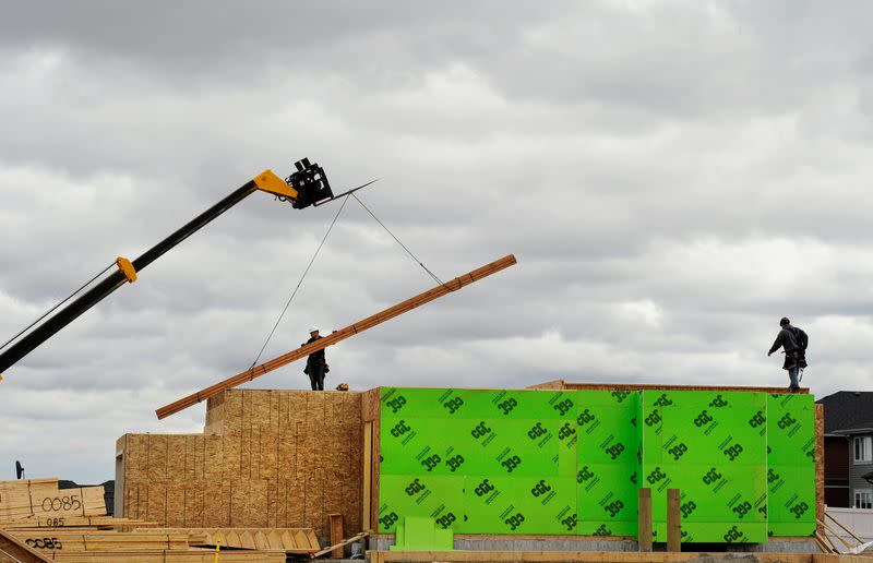 FILE PHOTO: Construction workers are seen alongside a crane as they build homes in Calgary, Alberta