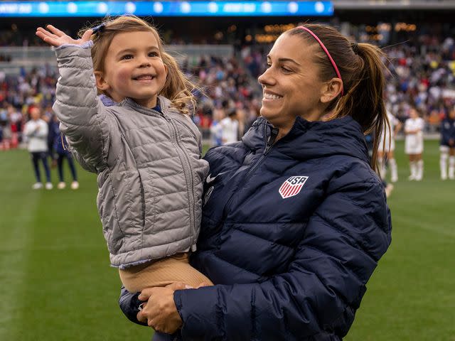 <p>Brad Smith/ISI Photos/Getty</p> Alex Morgan holds her daughter Charlie Carrasco after a game in February 2023