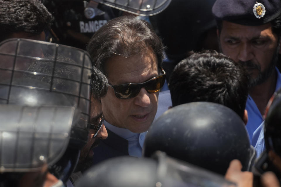 Pakistan's former Prime Minister Imran Khan, center, is escorted by police officers as he arrives to appear in a court, in Islamabad, Pakistan, Friday, May 12, 2023. A high court in Islamabad has granted former Prime Minister Imran Khan a two-week reprieve from arrest in a graft case and granted him bail on the charge. (AP Photo/Anjum Naveed)