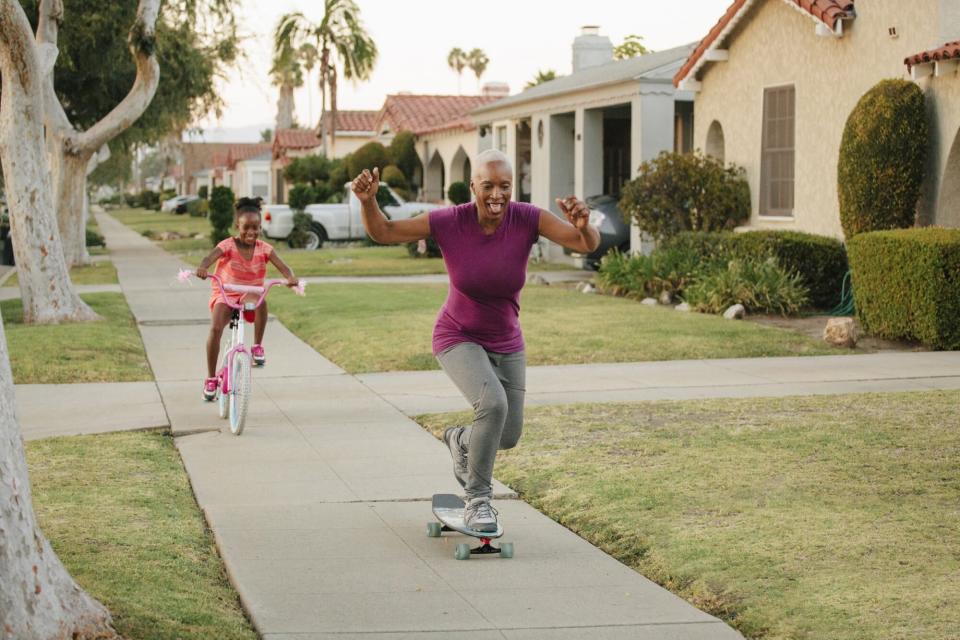 woman riding skateboard on sidewalk