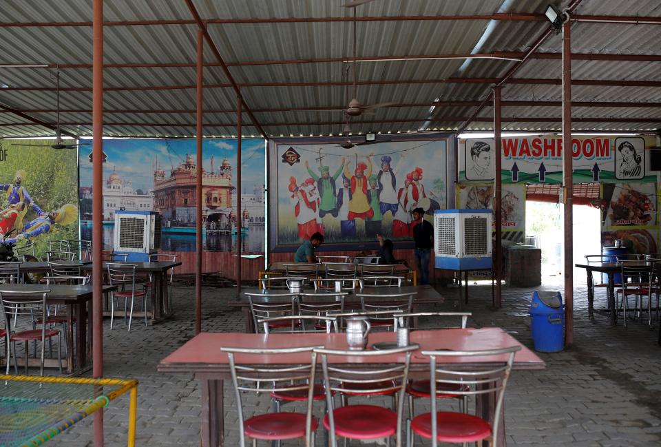 Waiters wait for customers at a dhaba, a small restaurant along a national highway in Gharaunda