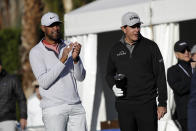 Tony Finau, left, and Phil Mickelson cheer as their amateur partner hits from the first tee during the first round of The American Express golf tournament at La Quinta Country Club on Thursday, Jan. 16, 2020, in La Quinta, Calif. (AP Photo/Marcio Jose Sanchez)