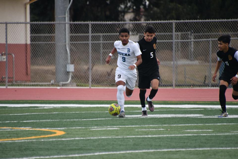 Buena High sophomore Nate Lopez holds off Oxnard defender Robert Vargas in a Channel League boys soccer match on Dec. 17.