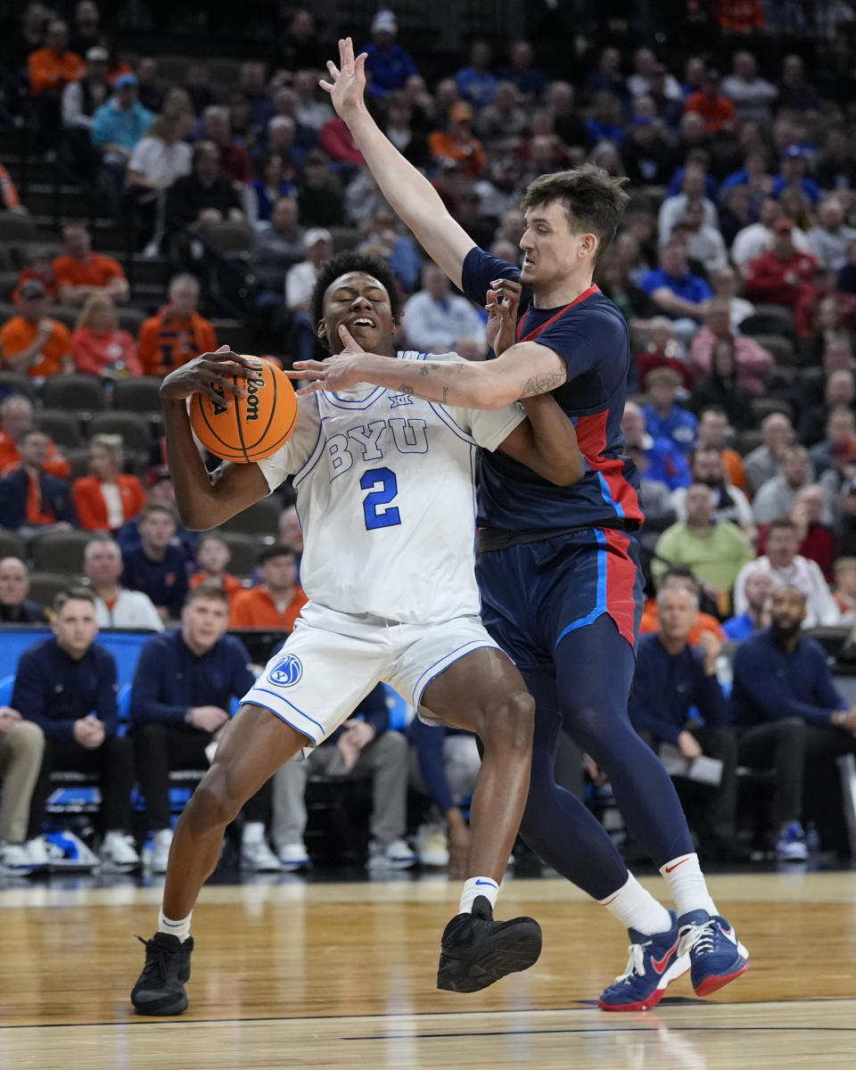 BYU guard Jaxson Robinson (2) is fouled by Duquesne forward Matus Hronsky (14) in the first half of a first-round college basketball game in the NCAA Tournament, Thursday, March 21, 2024, in Omaha, Neb. (AP Photo/Charlie Neibergall)