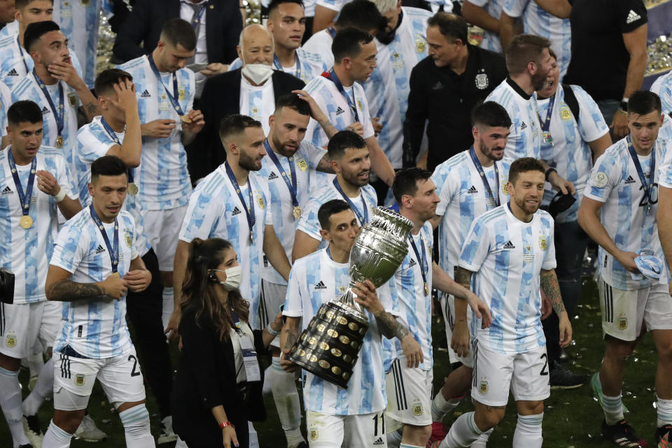 Argentina's Angel Di Maria kisses the trophy as he celebrates with teammates after beating 1-0 Brazil in the Copa America final soccer match at the Maracana stadium in Rio de Janeiro, Brazil, Saturday, July 10, 2021. (AP Photo/Silvia Izquierdo)