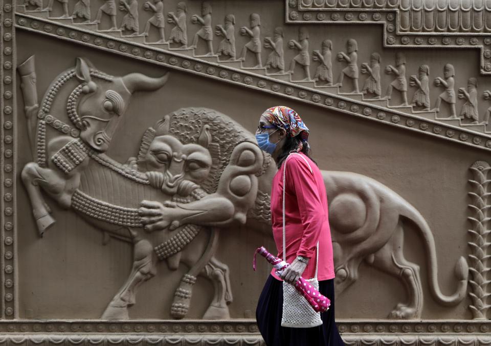 A Parsi woman wearing mask as a precaution against the coronavirus enters a prayer hall near a Fire Temple during Parsi New Year in Mumbai, India, Sunday, Aug. 16, 2020. (AP Photo/Rajanish Kakade)