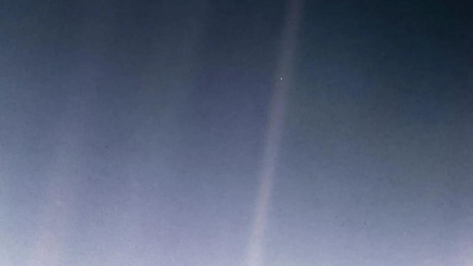 Photograph of Earth as a pale blue dot taken from space billions of miles away