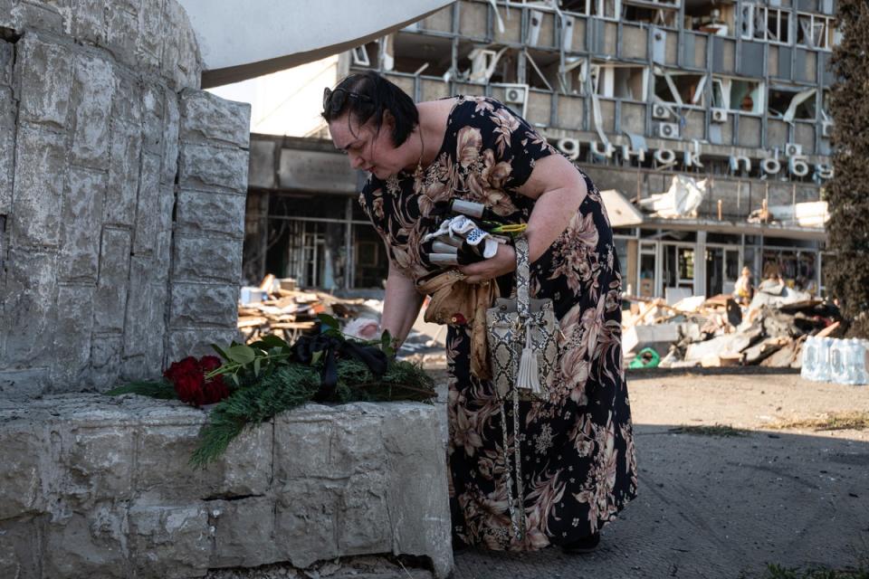 A woman lays flowers and a toy at the scene of the attack in Vinnytsia, Ukraine. (Getty Images)