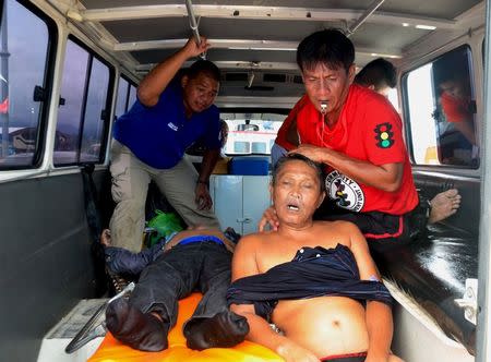 Rescuers attend to the bodies of dead victims following the capsize of a ferry, inside an ambulance in Ormoc city, central Philippines July 2, 2015. REUTERS/Ronald Frank Dejon