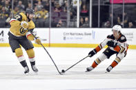 Vegas Golden Knights defenseman Shea Theodore (27) and Anaheim Ducks center Trevor Zegras (11) vie for the puck during the second period of an NHL hockey game Thursday, April 18, 2024, in Las Vegas. (AP Photo/David Becker)