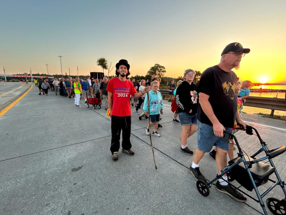 Chris Cowie (red shirt) showed his enthusiasm for this year's Mackinac Bridge Walk by bringing his own walking stick and lining up early to be one of the first people on the bridge at 6:30 a.m. on Monday, Sept. 4, 2023.